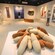 A man and a woman examine art pieces in a museum gallery filled with paintings and sculptures 