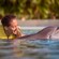 A woman in a pool with a dolphin