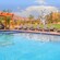 A pool and a hot tub with lounge chairs along the side
