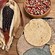 A tray of tortillas beside a bowl of corn and corn on the cob