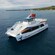 A catamaran floating in the ocean with the coastline in the distance