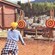 A man and a woman dressed as lumberjacks standing next to 2 target boards