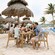 A family of 4 sitting at a table, clinking their glasses together