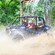 Guests in an off road vehicle driving through a muddy area