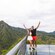 A man and woman posing on an observation deck with mountains in the background