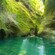 Two swimmers navigate through an opening in the rock formations at Titou Gorge