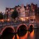 Gabled buildings next to a canal with a bridge 