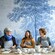 4 women laughing and smiling while painting pottery