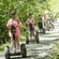 Guests wearing helmets on Segways lined up on a trail