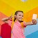 A girl taking a selfie in front of a bright, multicolored wall