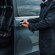 A private driver opening the door of a luxury mini bus