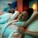 A man and a woman with their eyes closed getting a massage on reclining massage chairs