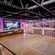 An upscale indoor basketball court and the words ‘Hero Zone’ projected on a large screen