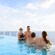 Four adults chatting inside the Quiet Cove Pool on board the Disney Treasure cruise ship