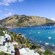 Waterfront houses with palm trees and a mountain overlooking the Caribbean Sea