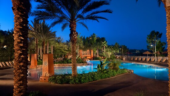 A swimming pool surrounded by lounge chairs and palm trees