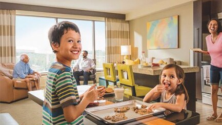 Two kids eat cookies in a hotel room