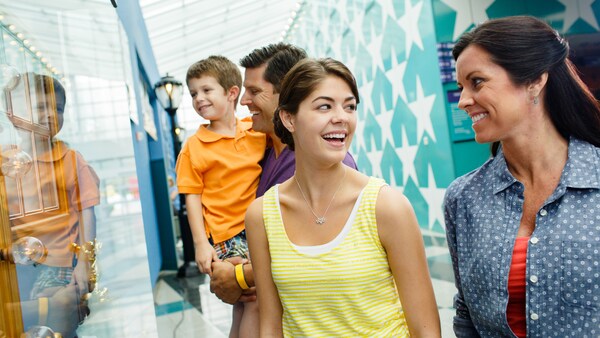 A father, son and other Guests in the main lobby at Disney’s All Star Music Resort