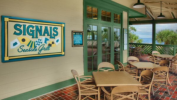 A sign saying ‘Signals Seaside Grill’ on a wall along an outside patio
