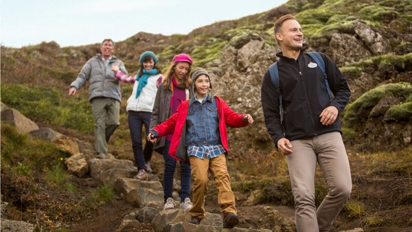 An Adventure Guide leads 4 Guests down a path of stone steps on a hill in Iceland