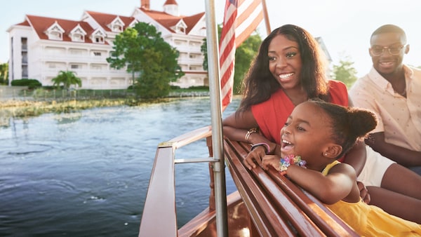 A young daughter looking over the side of a boat with her parents
