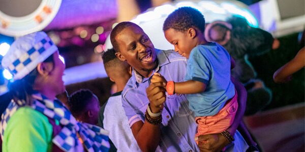 A happy father holds his smiling young son in his arms