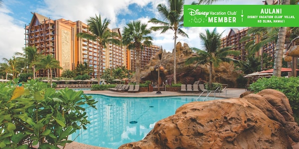 A pool, with some Aulani buildings in the background, over which a banner reads, ‘Disney Vacation Club Member, Aulani Disney Vacation Club Villas, Ko Olina, Hawaii’