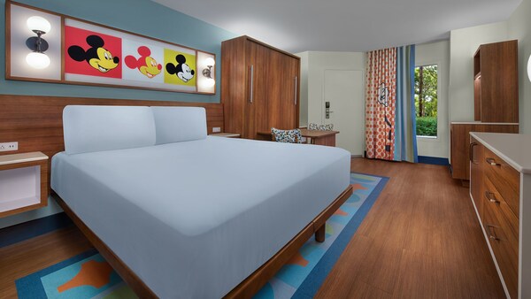 Quarto de hotel Standard com cama queen ao lado de uma mesa e cadeiras no Disney's Pop Century Resort