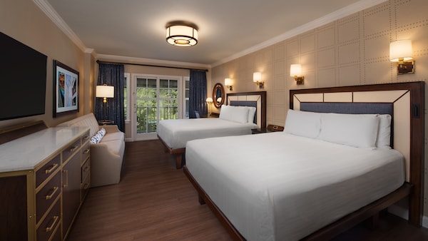 A room with 2 beds, drawers, a couch, a TV, a painting, lamps, a mirror, curtains and balcony access Walt Disney World Deluxe Resort Yacht Club Choosing the Perfect Room Category