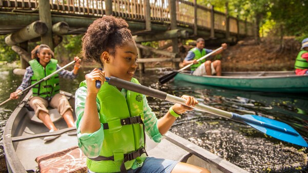 Una mujer y su hija remando en su canoa cerca de un puente