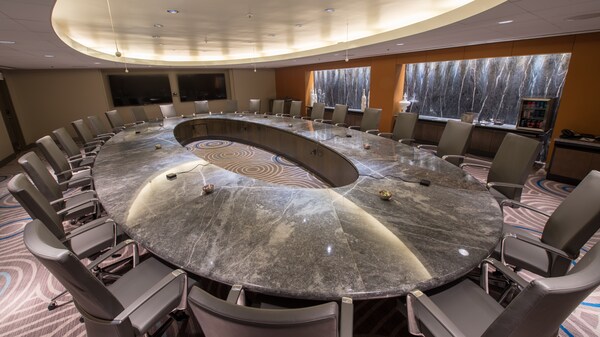 Une table de conférence de forme ovale et plusieurs chaises