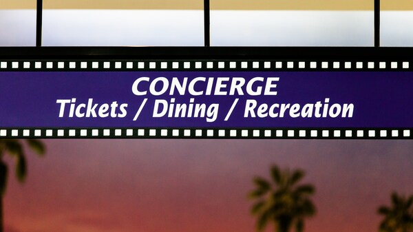 Panneau en forme de pellicule indiquant en anglais : « Concierge, Billets/Restaurants/Activités récréatives »