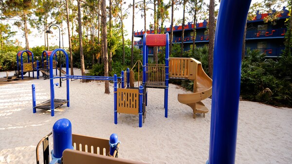 Une aire de jeux sablonneuse avec des modules à grimper, des filets et une glissade au Disney’s All-Star Music Resort