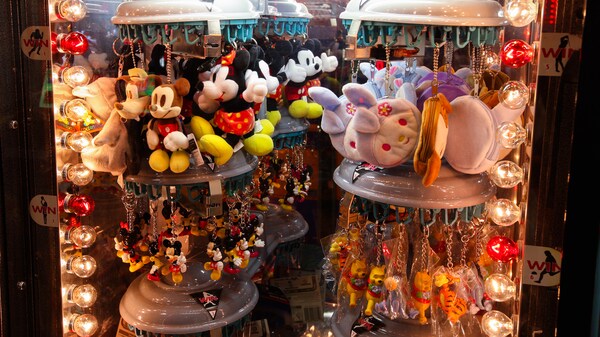 Assortiment de porte-clés à peluches, de Mickey Mouse à Winnie l’ourson, sur un présentoir