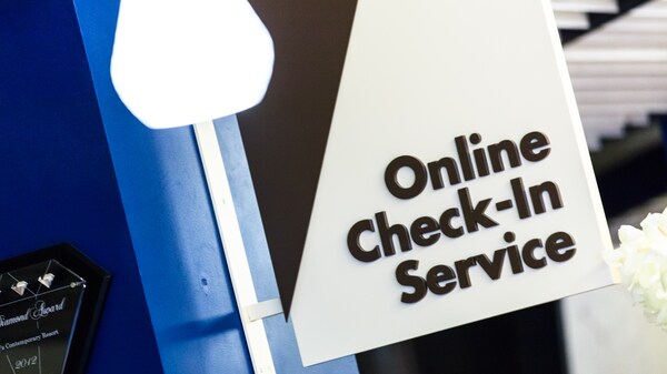 Panneau, dépassant d’un mur, indiquant : « Online Check-In Service »