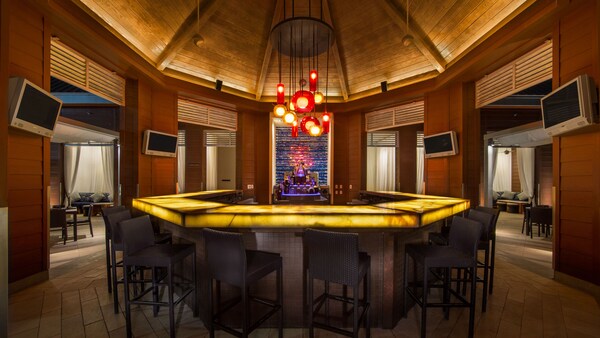 A bar surrounded by seats and TV monitors