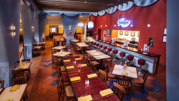 A seating area in a restaurant with a bar near a sign that reads The Fountain