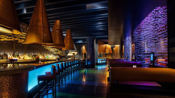 A lounge area with a bar, chairs and booths