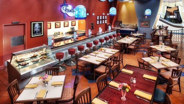 Una cena clásica con un área de bar, mesas, sillas y un cartel en la pared que dice ‘The Fountain’