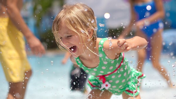 Water splashes about as a young female Guest enjoys a pool area at Disney’s Port Orleans Resort