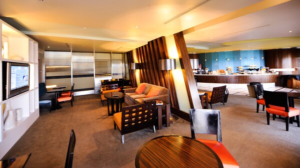 Lounge area in a Walt Disney World Resort hotel next to a room with a buffet table of baked goods