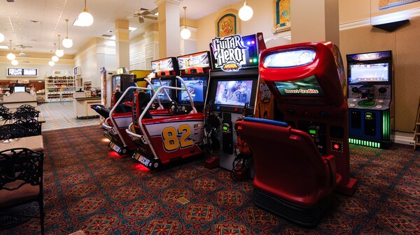 A brightly lit quick service restaurant with video games and dining tables