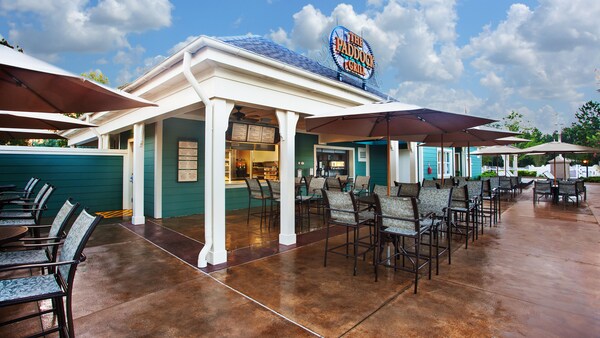 Exterior of The Paddock Grill, with umbrellaed patio tables