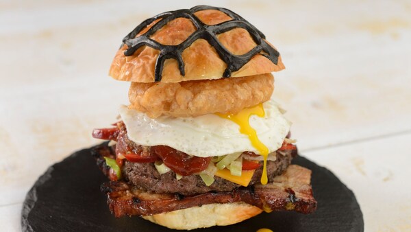 A sandwich featuring fried foods and an egg served on a plate