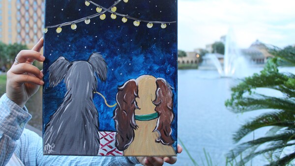 Un tableau de la Belle et le Clochard qui mangent du spaghetti tenu près d’une étendue d’eau au Disney’s Coronado Springs Resort.