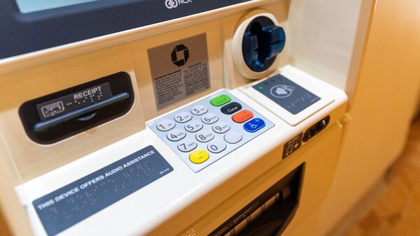Un guichet automatique de l’hôtel comporte une affiche en gros caractères et des panneaux d’instructions en braille