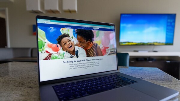 Un écran sur un ordinateur portable indique « Préparez-vous pour vos vacances à Walt Disney World »
