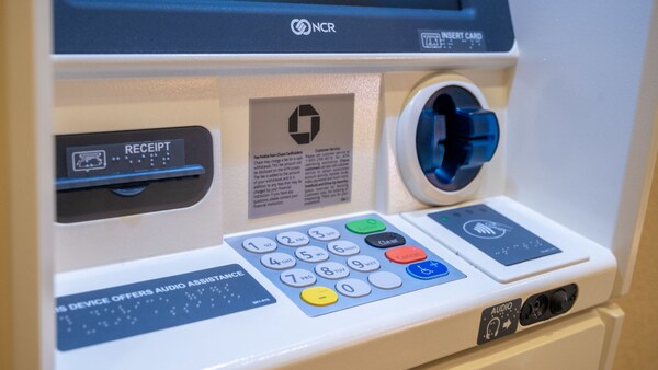 The front of an ATM with a number keypad, credit card input slot and braille instruction panels