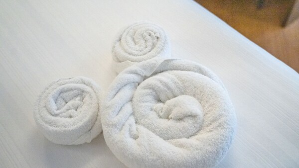Toallas dobladas en forma de Mickey Mouse en una cama de una habitación en Disney’s Yacht Club Resort