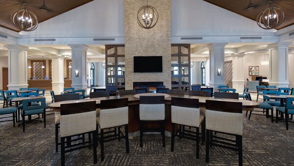 Un comedor con mesas, sillas y una barra de desayuno dentro de un hotel